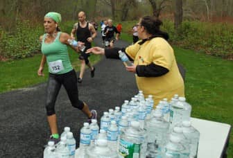 Denise Doktor, volunteer from the Goodwill Industries of RI hand out water at the first mile marker during  the Rocky Point 5K on May 10, 2014.