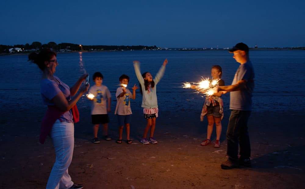 Scott and Cheryl Marble light up some sparklers with Faith Kennedy, 10, Teagan Marble, 10, Aiden Duffy, 10, and Daniel Kennedy, 8,.
