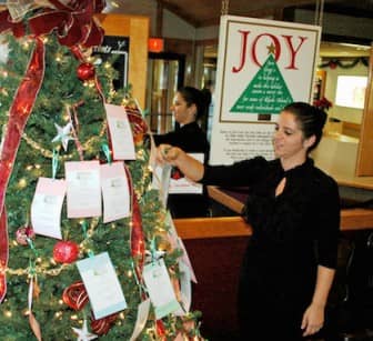 Trish Rego, General Manager at Gregg's Restaurant in Warwick, replaces an ornament tag on the restaurant's Giving Tree.