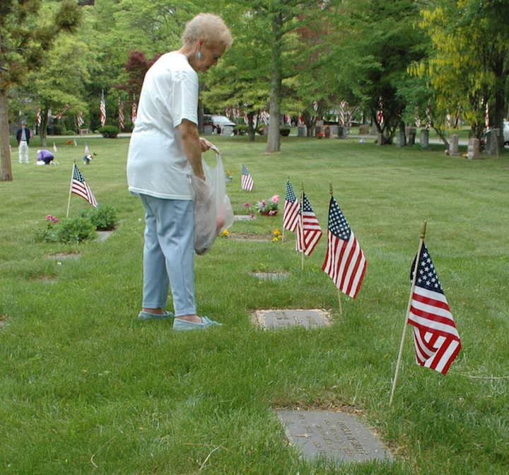 Hazel Paquin tends to the graves of her husband, William, who served in the National Guard in the US during Vietnam, and her fathter, Edgar, who served in the Coast Guard in WWII and mother, Hazel Mott.