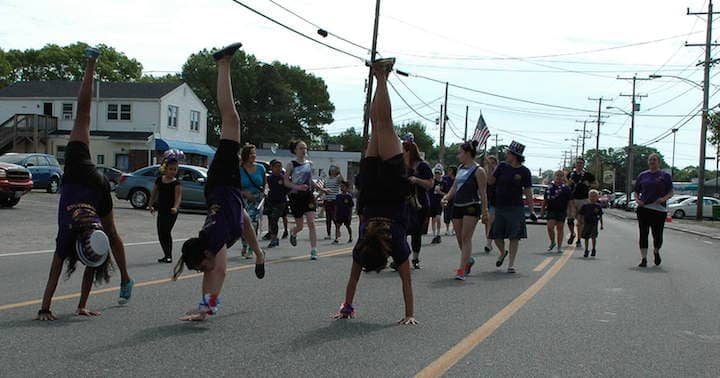 Members of the Providence Turners Gymnastics Team Flip past spectators during Warwick's Memorial Day Parade.
