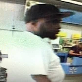 A video still shot of a man police say took a credit card left at WalMart and used it to buy sneakers, movie tickets and Chinese food.