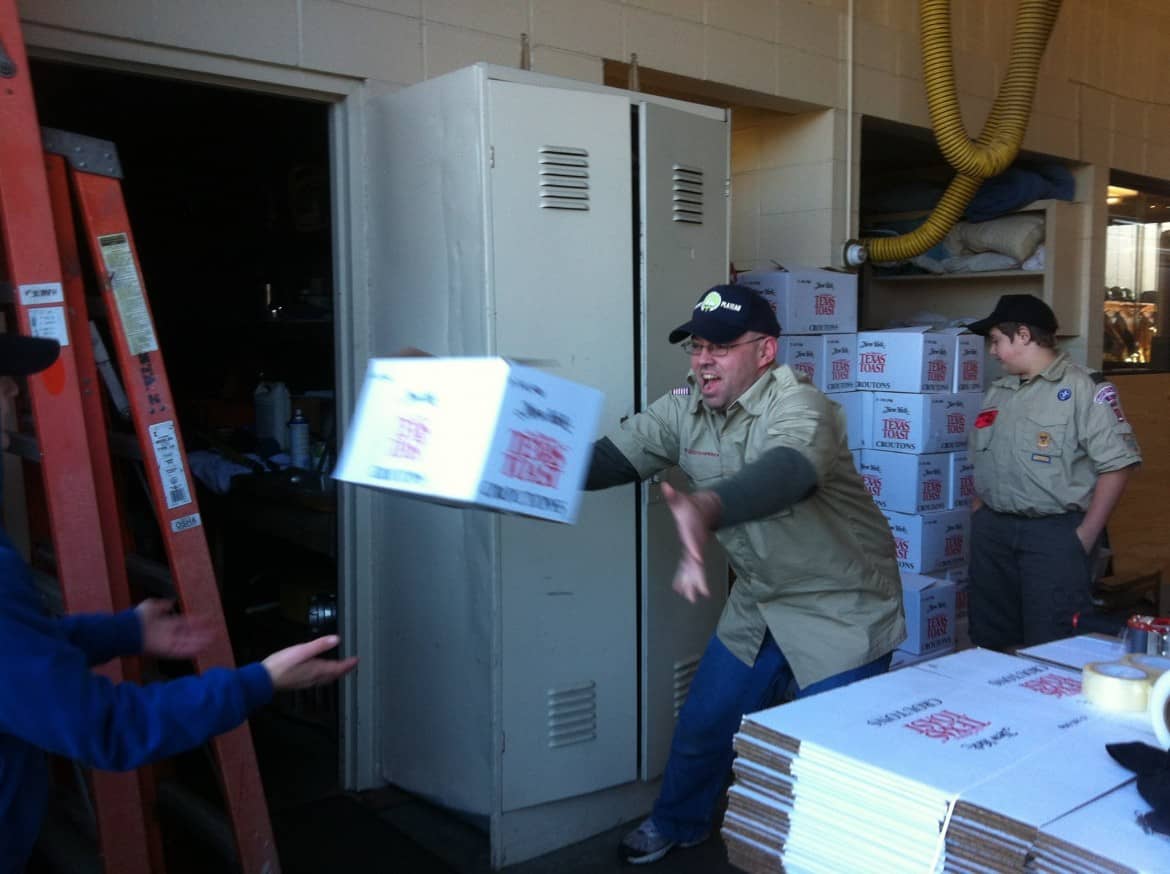  Troop 1 Gaspee Plateau Scout leader Phil Nemirow, Sr., tosses a box to a Scout during the 2014 Scouting for Food Drive.