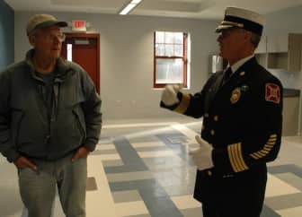 [CREDIT: Rob Borkowski] At left, Assistant Fire Chief Bruce Cooley talks about the new station with his father, Gordon, inside the building's community room.