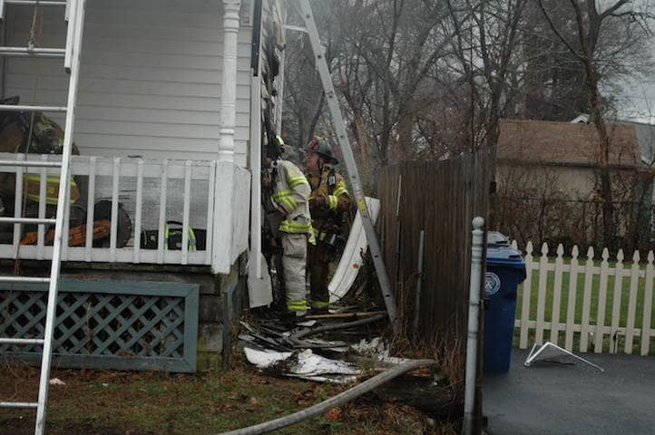 Warwick firefighters took off strips of siding searching for pockets of flame after bringing a fire in the vacant house under control Dec. 18.