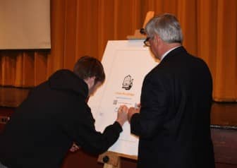 [CREDIT: Emily Martineau] A Pilgrim High School student joins Attorney General Peter F. Kilmartin to take a pledge never to drive while distracted.