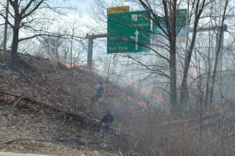 [CREDIT: Rob Borkowski] Firefighters bring a water line to bear on a brush fire on the Rte. 37 overpass on Jefferson Boulevard today at about 2:30 p.m.