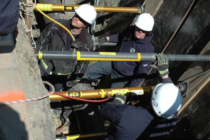 [CREDIT: Rob Borkowski] WFD Firefighters Tom Maymon Jr., Michael Carvahalo, and Ben Shermack-Moore practice trench rescue tactics at the Local 57 facility in Johnston. An airbag used to lift the pipe off the "victim" in the exercise is visible in the bottom left corner. 