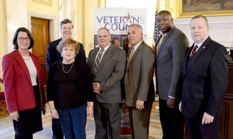 [CREDIT: Leg. Press & Public Information Bureau] Rep. Eileen Naughton, left front, poses with guests at a reception welcoming Veterans Count to Rhode Island on Wednesday at the State House. From left are Secretary of Health and Human Services Elizabeth H. Roberts, Sen. Walter S. Felag Jr., Rep. Dennis M. Canario, House Veterans’ Affairs Committee Chairman Jan P. Malik, Director of Veterans’ Affairs Kasim Yarn and Veterans Count Chairman of the Board Jim Lawrence.