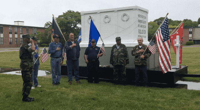 CREDIT: Rob Borkowski] From left, Dennis Mullen leads veterans in the Pledge of Allegiance beside The Tomb of the Unknown Soldier float, at Warwick Veterans Memorial on West Shore Road.