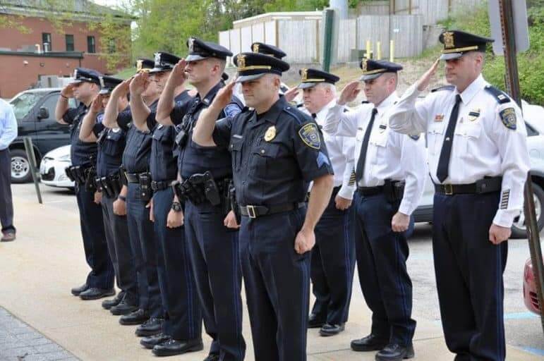 [CREDIT: Ret. Officer Yerv Parnagian] Members of the Warwick Police Department salute in honor of the department's five fallen officers during the dedication of a memorial to them May 18.