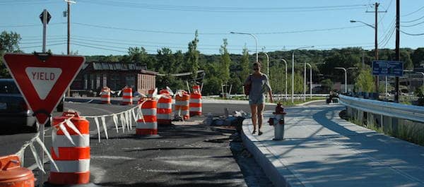 [CREDIT: Rob Borkowski] Cars aren't using the Veterans Memorial Drive Extension yet, but pedestrians are, as is this woman, who was walking past Greenwich Avenue Monday.