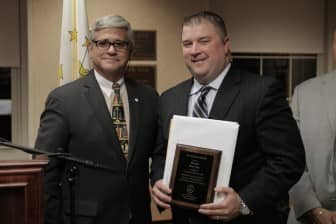 [CREDIT: RIAG] Attorney General Peter Kilmartin presents Warwick resident and Providence Police Detective Brian Dyer with the Attorney General Herbert DeSimone Award for Law Enforcement – Non Uniform for leading the investigation into the 1978 cold case homicide of Bobby Oliveira.