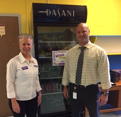 [CREDIT: Tutor Doctor RI] Patti Avin, owner of Tutor Doctor RI, and Warwick Veterans Middle School Principal David Tober after the two stocked the school's fridge.