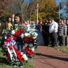 [CREDIT: Rob Borkowski] Hailey Norman, 6, holds a wreath for the memorial at Veterans Memorial Park near Veterans Memorial Middle School Friday.