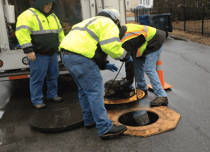 [CREDIT: Rob Borkowski] WSA subcontractors lower a smoke bomb into a manhole on Haven Street.