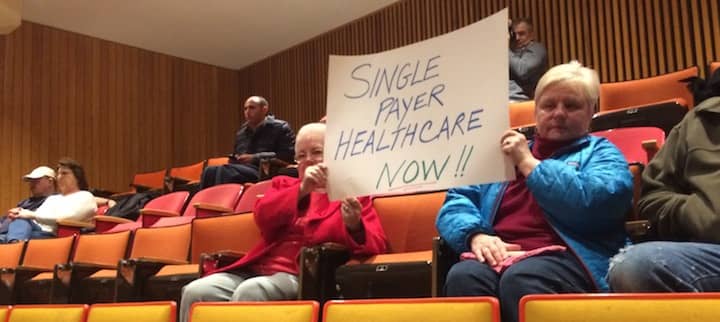 [CREDIT: Rob Borkowski] Andrea Penardo and Aline Sweeney hold a sign urging a move to a single-payer healthcare system as their own alternative to Obamacare at Coventry High School during a Congressional Town Hall meeting with Senators Jack Reed and Sheldon Whitehouse and Congressman Jim Langevin.