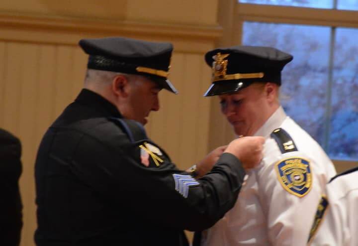  [CREDIT: Rob Borkowski] Sgt. James Michailides pins the new rank on the uniform of his wife, newly promoted Captain Lori A. Michailides. 