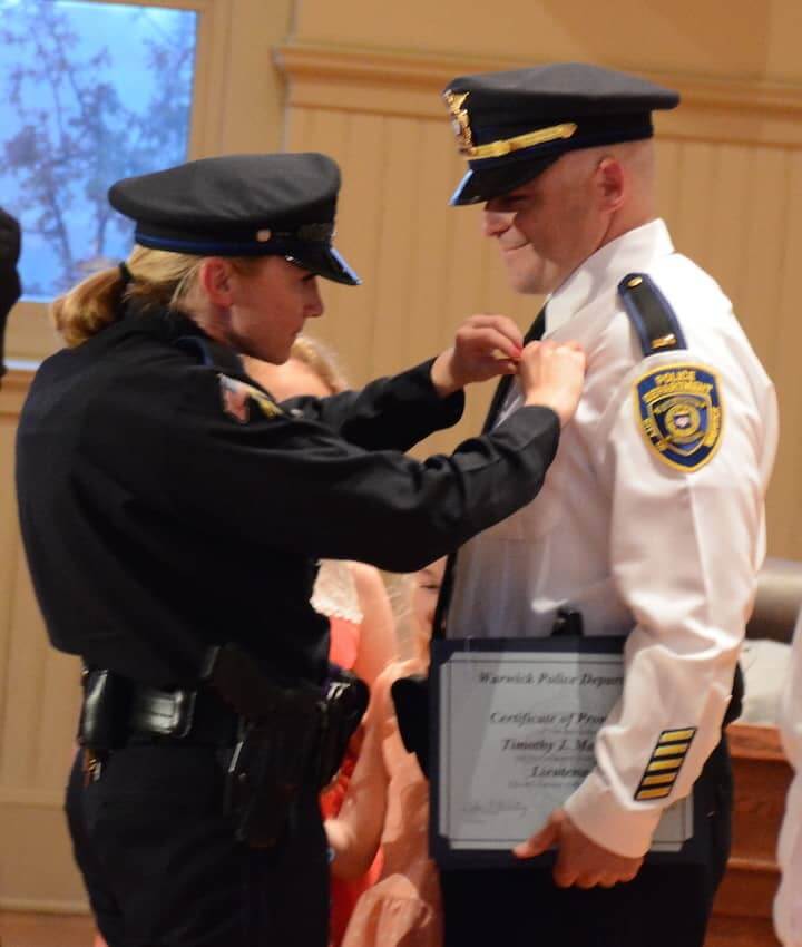 [CREDIT: Rob Borkowski] Officer Julie Marshall pins new Lieutenant rank on her husband, Timothy Marshall.