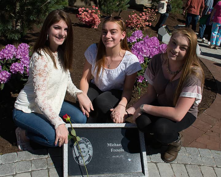 [CREDIT: Mary Carlos] Emily and Maria Fresolo next to the stone for their father, Michael A. Fresolo, with their cousin Toni Fresolo the Station Fire Memorial dedication.