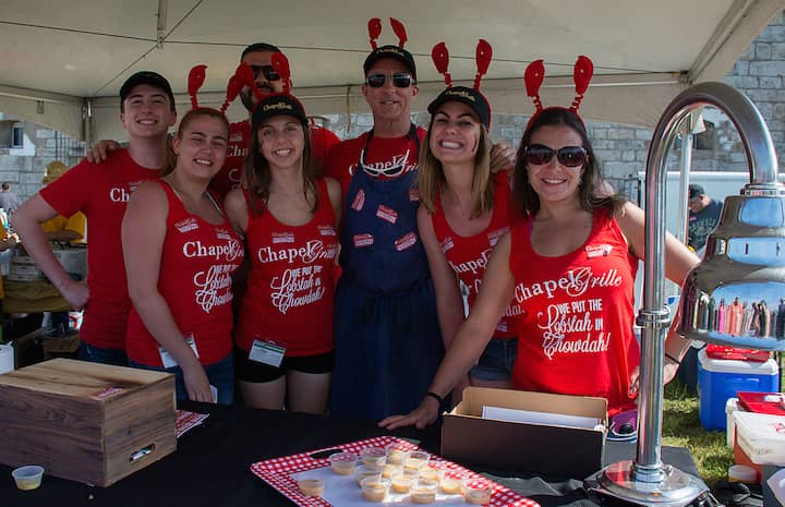 [CREDIT: Mary Carlos] Chapel Grille's team at the Great Chowder Cook-Off at Fort Adams, Newport. Smiling for the camera are: Erin Pimental, Darien Jewell, Tim Kelley, Vittoria Devin, Tori Picchione, Kusta Fillipou, and James Dunbar.