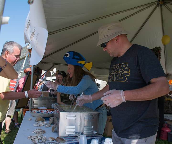 [CREDIT: Mary Carlos] Greenwich Bay's team members Terri Aquiar and Nathan Bard serve chowder during the Great Chowder Cook-Off at Fort Adams, Newport.