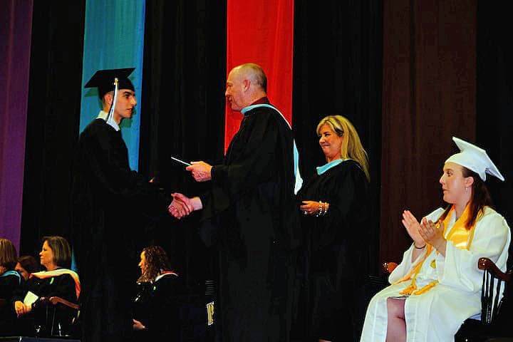 [CREDIT: Lauren Kasz] Principal Gerald Habershaw shakes the hand of a new graduate at CCRI during the Pilgrim High School Class of 2017 graduation.