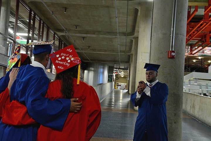 [CREDIT: Rob Borkowski] Nick Zulla takes a photo of Gwendolyn Kalian, Nick Kazandjian, and Lauren Kellerman as they wait for their diplomas Tuesday at CCRI. 