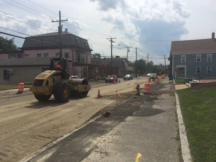 [CREDIT: Rob Borkowski] A road roller packs down one lane of Post Road in front of City Hall, shaking the sidewalk and the building.