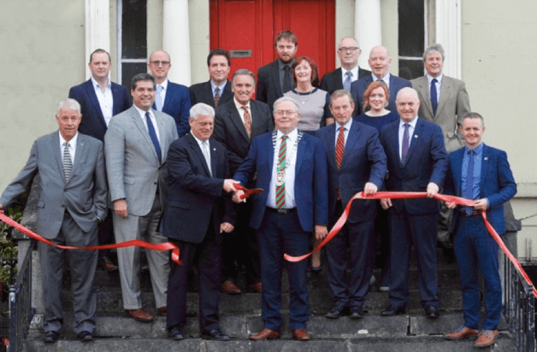 [CREDIT: Courtesy Photo] Launch of the Rhode Island Trade & Tourism Center in the US Innovation Showroom located in downtown Castlebar, Mayo on September 20. Front rows, left to right: Roy Coulombe, CEO, Royal Advisors and Consultants; Richard Pinto, CEO, Fabiani Pinto; Scott Avedisian, Mayor of Warwick, Rhode Island; JR Pagliarini, President, Fabiani Pinto; Richard Finn, Mayor of Mayo County; Louise Ward, Head of Local Enterprise Office Roscommon; Enda Kenny, former Prime Minister of Ireland; Elaine Moyles, Business Advisor, Local Enterprise Office Mayo; Peter Hynes, Chief Executive, Mayo County Council; John Magee, Head of Local Enterprise Office Mayo. Back row, left to right: Brian Hopkins, Managing Director, Ezewarm Ireland Ltd, and Chairman, Mayo Chambers of Commerce; Wilson Bird, General Manager, Breaffy House Resort, and President, Castlebar Chamber of Commerce; Joseph Iovini, Vice President, Dean Warehouse; Paul Corrigan, Business Advisor, Local Enterprise Office Mayo; Michael O’Boyle, Marines Development Office, Mayo County Council; John Reilly, Head of Local Enterprise Office Sligo; Iain Douglas, Senior Planner, Mayo County Council. 