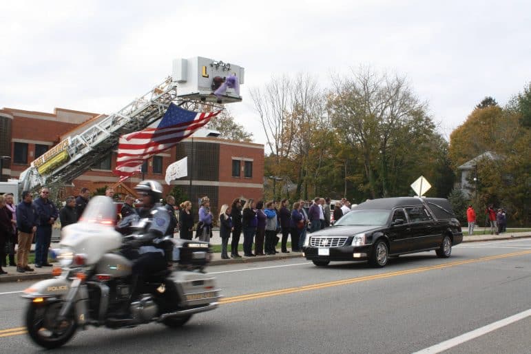 [CREDIT: Beth Hurd] A police honor guard, including members of the WPD and EGPD, precede a funeral procession for Gianna Cirella on Tuesday, Nov. 7, while members of the East Greenwich community line the streets in front of the EG police station to pay their respects.