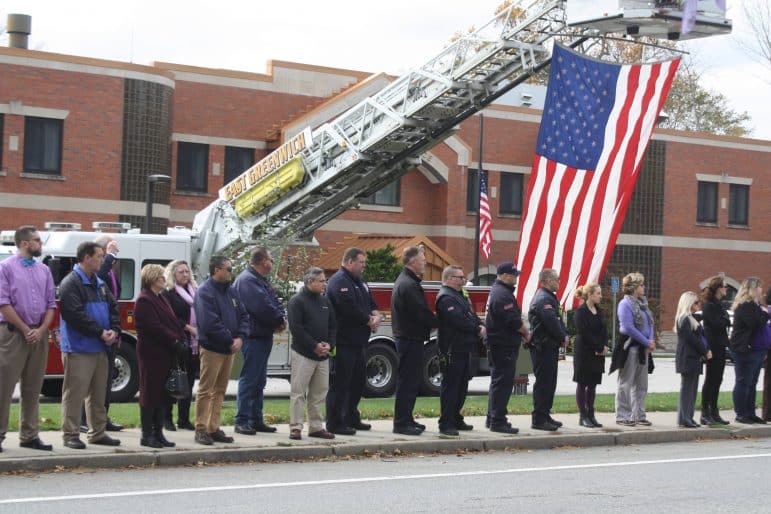 [CREDIT: Beth Hurd] East Greenwich community members and town employees line the street in front of the EG police station 