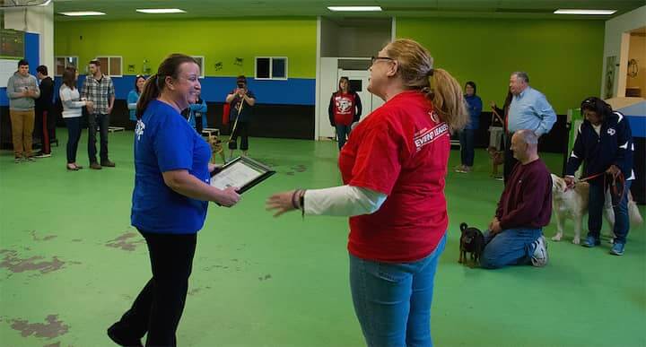 [CREDIT: Rob Borkowski] Heidi Durand-Lenz, owner of Bow Chicka Wow Town, accepts an award from Lynne Peters during the end of the 2018 Bark for Life.