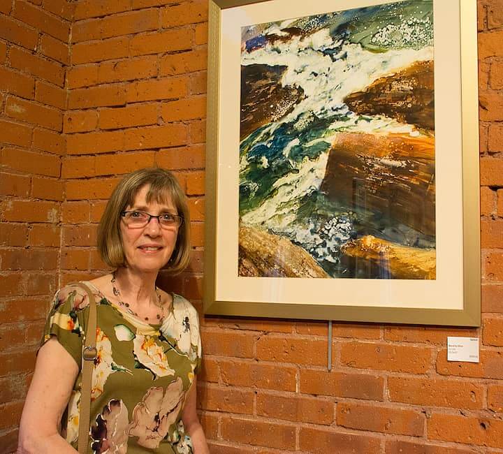 [CREDIT: Mary Carlos] Artist Beverly Silva with her work, "Splash" during the opening reception for the "Sights and Sounds" juried art exhibit at the Warwick Center for the Arts May 3.