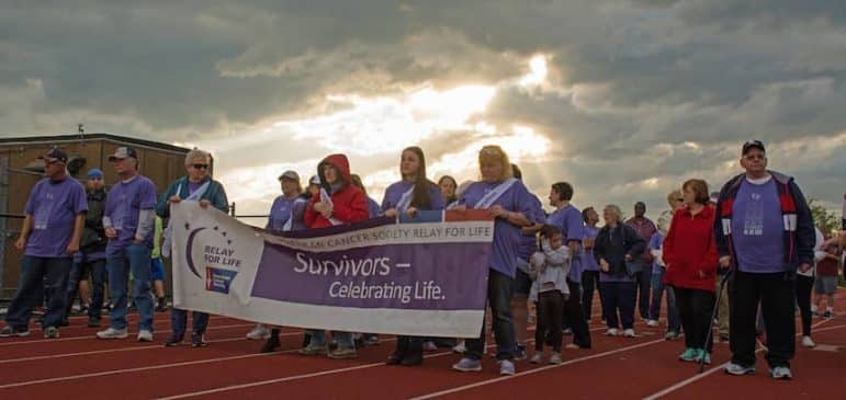 [CREDIT: Mary Carlos] Survivors of cancer march during a themed lap around West Warwick's High School track during the Relay for Life in 2017.