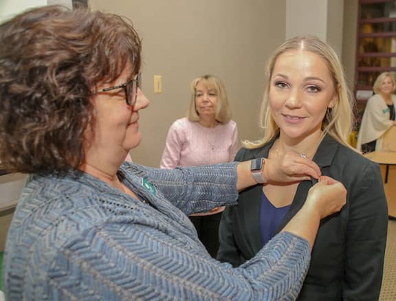[CREDIT: CCRI] Irina V. Diffley of Warwick recently was inducted into the Gamma Lambda Chapter of Alpha Delta Nu nursing honor society at CCRI. Pictured above, Professor Linda A. Ethier pins Diffley at the ceremony.