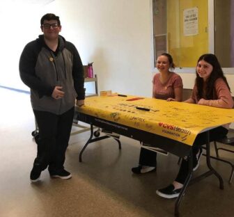 [Message Partners PR] Pilgrim High School students Cameron Costanza(standing), Alexis McCabe  and Ivy McCormick (seated l-r) gathered signatures from students pledging to #bethefirst generation to be tobacco free March 20.