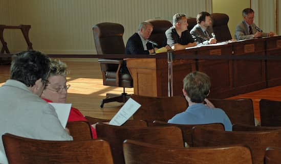 [CREDIT: Rob Borkowski] School Committee Chair Karen Bachus consults with fellow School Committee person Judy Cobden. School Committee member Nathan Cornell is seated in front of them.