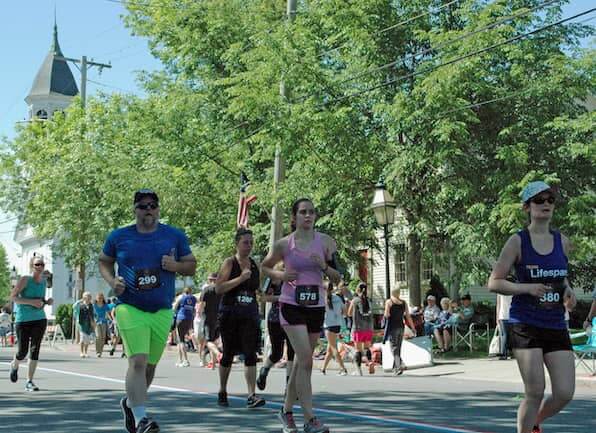[CREDIT: Rob Borkowski] Runners near the final turn into the lot for Rhodes on the Pawtuxet during the 2019 Gaspee Days 5K Saturday.