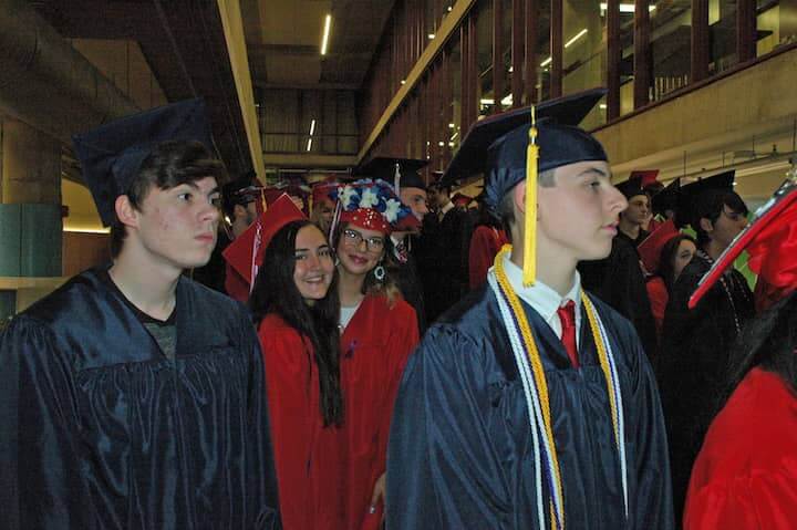 {CREDIT: Rob Borkowski]] In front, Logan Heberg and Morgan Henderson' Center, Kara Hulstein and Calia Howard wait inside CCRI's main building on the ramp to walk in to graduation in the field house.