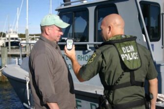 [CREDIT: DEM] Officer Hill uses a portable breath test instrument to measure a boater’s blood alcohol level.