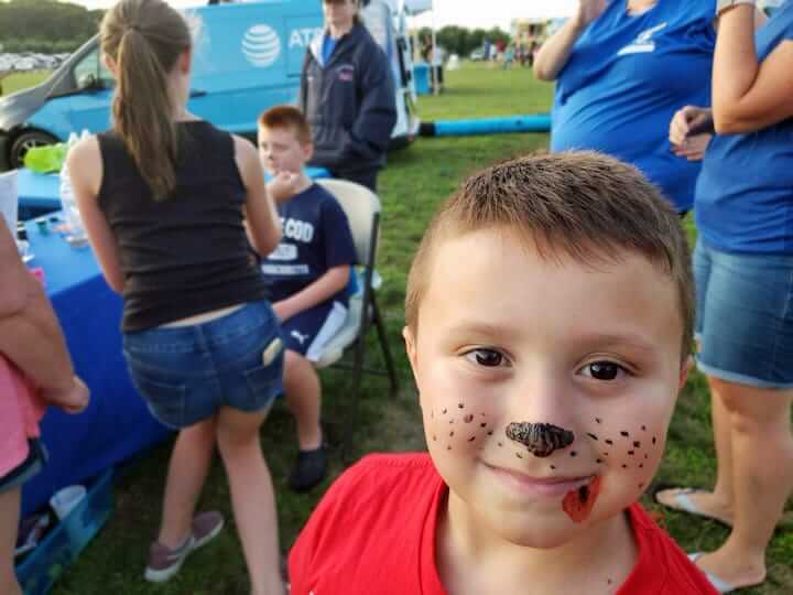 [CREDIT: Rob Borkowski] At Movies in the Park, showing Spider-Man: Into the Spiderverse July 25 at Rocky Point Park, Logan, 5, shows off some face paint as his brother, Landon, 9, gets his own. The two were attending the even with their aunt, Laurie.