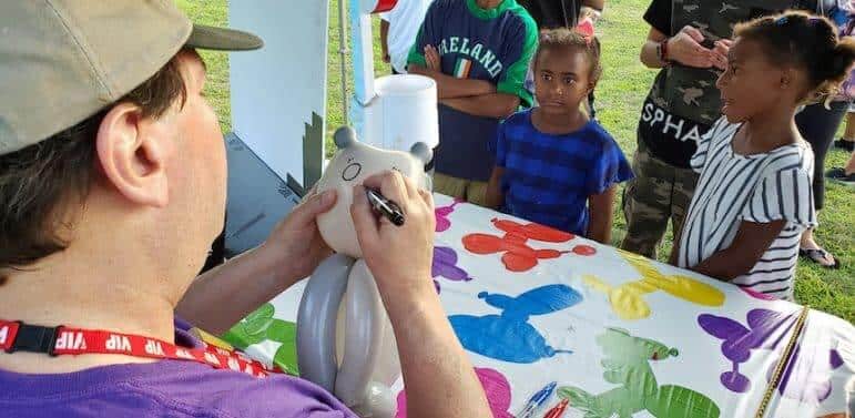 [CREDIT: Rob Borkowski] At Movies in the Park, showing Spider-Man: Into the Spiderverse July 25 at Rocky Point Park, Symia, 7, waits for a balloon cat from Anthony Marrapese, of Balloon Twisting by AntKnee.