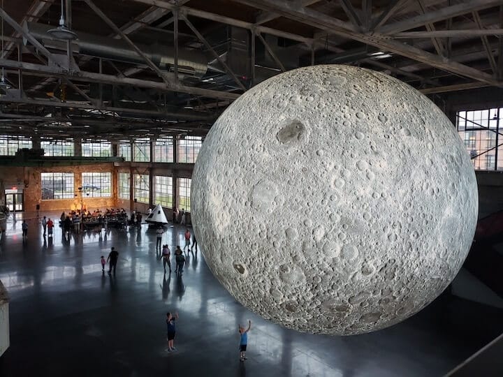 [CREDIT: Rob Borkowski] An enormous replica of the moon sits inside the Water Fire Arts Center, 475 Valley St., Providence, above a Warwick-crafted replica of the Apollo 11 command module. The exhibit runs through July 28.
