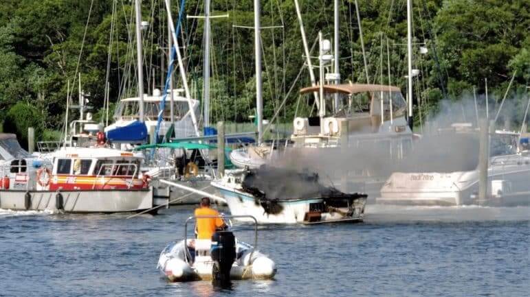 [CREDIT: Lincoln Smith] Marine 4 extinguishes a boat fire Saturday at the Fair Winds Marina.