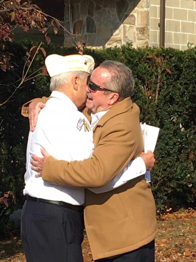 [CREDIT: Kim Wineman] Disabled American Vets (DAV) Chaplain James Hickey and Councilor Jim Mcelroy embrace during Veterans Day ceremonies at Warwick Veterans Memorial Jr. High Nov. 11, 2019. 