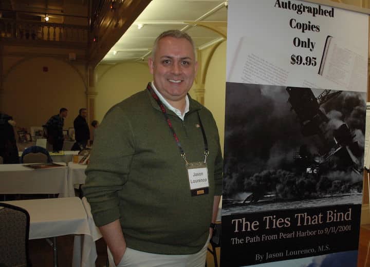 [CREDIT: Rob Borkowski] Author Jason Lourenco with his book, 'The Ties that Bind" about the historical journey from Pearl Harbor to the Sept. 11 attacks, at the RI Author Expo at Rhodes on the Pawtuxet.