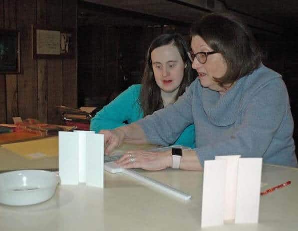 [CREDIT: Rob Borkowski] Katie Lowe and her mom, Claudia, work together on a greeting card in their basement workshop.