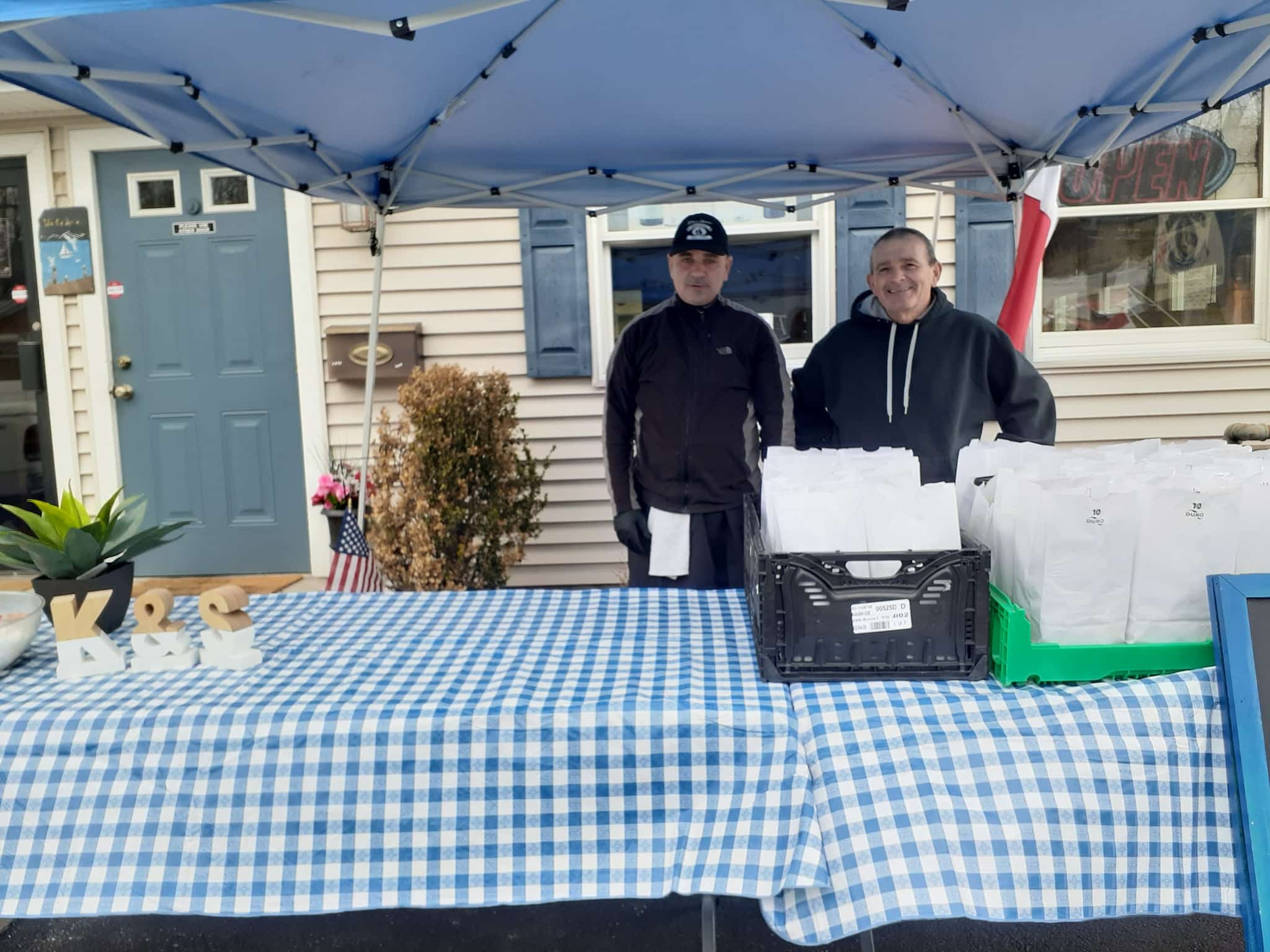 [COURTESY PHOTO] Kim-&-Steve's-Masthead-Grill is giving free take-out lunches to shut-in families during the COVID-19 outbreak. Restaurant employees, from left, Chuckie and Gary, were handing out the lunches Monday.
