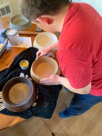 [CREDIT: Gail McCusker] Nic Votolato puts the finishing touches on a few dog bowls, the first items sold at Rock Solid Creations.